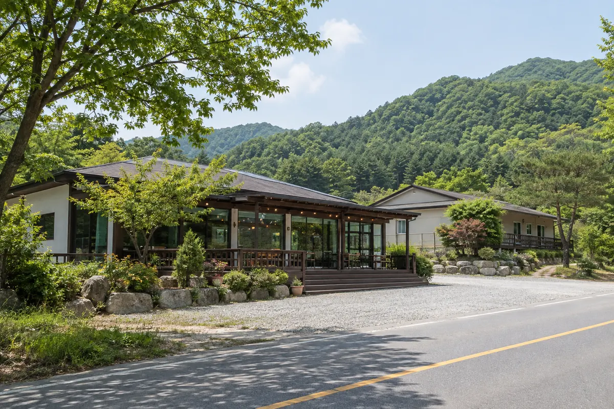 산을 배경으로 한 도로변 단층 식당·펜션 건물